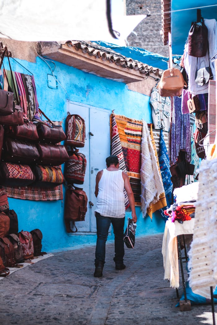 service-02 Explore the lively market alley filled with textiles and bags in Chefchaouen, Morocco.