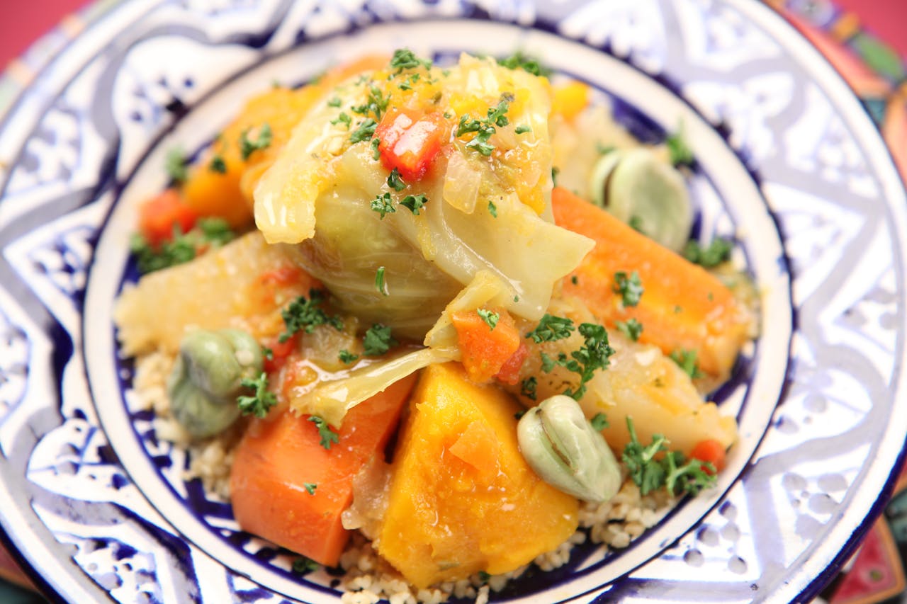 testimonial-img Close-up of a traditional Moroccan vegetable couscous served on an ornate plate.