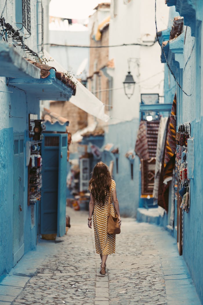 service-01 A woman wanders through the vibrant blue alleyways of Chefchaouen, Morocco.