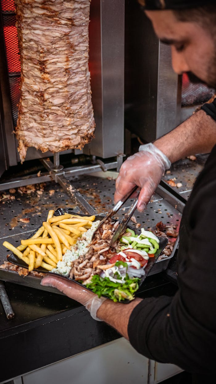 Chef preparing shawarma with fries and salad, showcasing Moroccan street food.